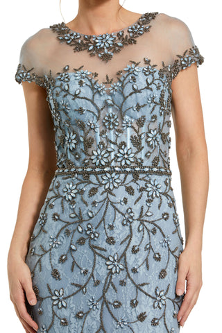 Close-up of the beaded floral applique, sheer illusion neckline and beaded waist band on the slate blue gown by Mac Duggal at Mrs. G