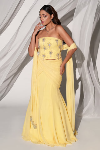 Three-quarter view of the butter yellow lehenga set with strapless blouse and fishtail skirt by Kiyohra at Mrs. G