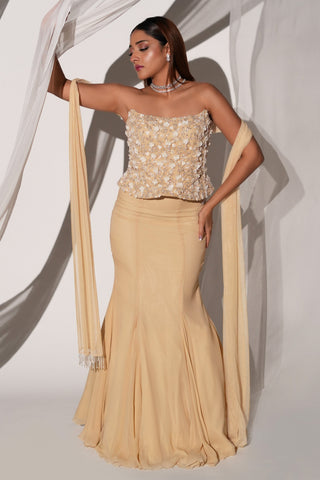 Full-length view of the beige lehenga set with one arm raised and the beaded dupatta hanging down by Kiyohra at Mrs. G