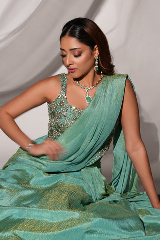 Seated view of the green crushed tissue saree-lehenga showing the gold sheen and floral blouse by Kiyohra at Mrs. G