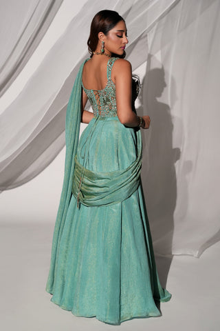Back view of the green saree-lehenga showing the lace-up blouse back and tasseled drape at the hip by Kiyohra at Mrs. G