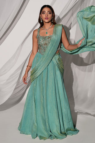 Front view of the green saree-lehenga with the drape flowing out to the side over the full skirt by Kiyohra at Mrs. G