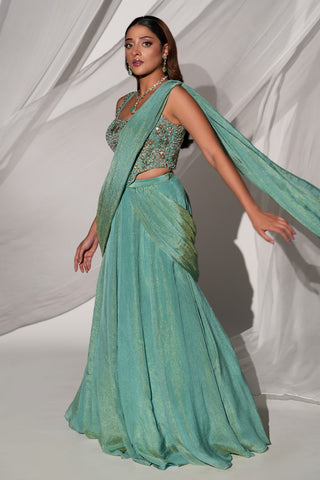 Side view of the green saree-lehenga with the long drape trailing behind and a floral beaded blouse by Kiyohra at Mrs. G