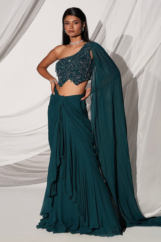 Full-length front view of the teal lehenga set with beaded one-shoulder blouse and long veil sleeve by Kiyohra at Mrs. G