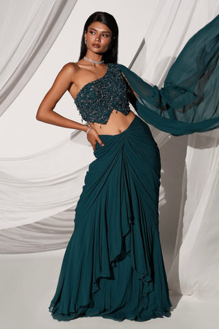 Full-length view of the teal lehenga set with the sheer veil sleeve lifting over the ruffled skirt by Kiyohra at Mrs. G