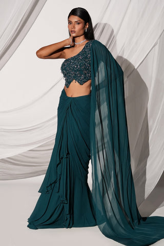 Three-quarter view of the teal lehenga set with the veil sleeve falling to a train by Kiyohra at Mrs. G