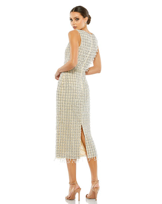 Back three-quarter view of the beige sheath dress showing the back slit and fringed hem by Mac Duggal at Mrs. G