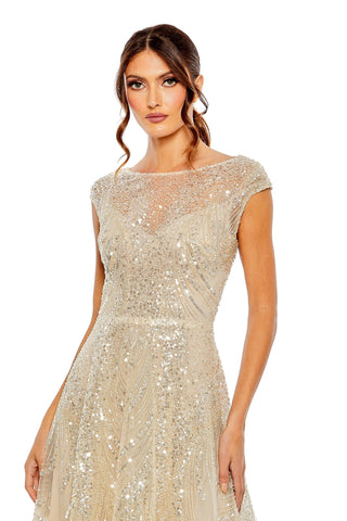 Waist-up view of the champagne silver cap sleeve high neck embellished A-line gown showing the sheer illusion neckline and sequin bodice by Mac Duggal at Mrs. G