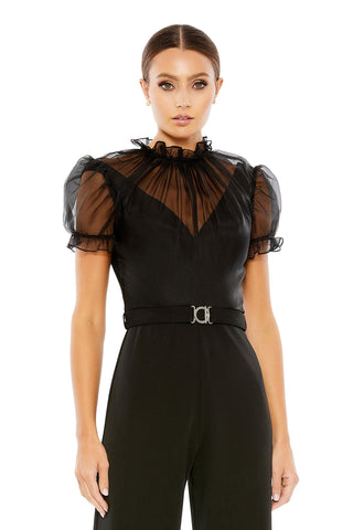 Waist-up view of the black illusion high neck belted jumpsuit showing the sheer ruffle collar, puff sleeves and silver belt buckle by Mac Duggal at Mrs. G