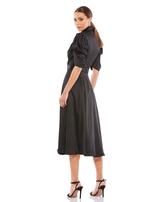Back three-quarter view of the black satin dress showing the fitted back and full A-line skirt by Mac Duggal at Mrs. G
