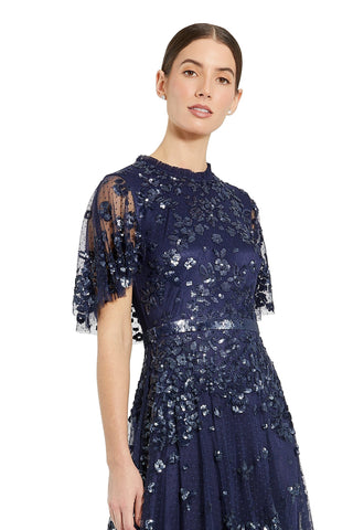 Waist-up view of the midnight sequined flutter-sleeve high-neck gown showing the high neckline, flutter sleeves and sequined bodice by Mac Duggal at Mrs. G