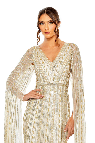 Waist-up view of the champagne silver beaded cape sleeve V neck column gown showing the V-neckline and beaded waistband by Mac Duggal at Mrs. G