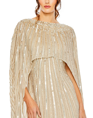 Zoomed-in close-up of the jeweled boat neckline and vertical sequin and bead lines on the champagne cape by Mac Duggal at Mrs. G