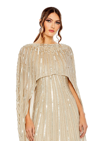 Waist-up view of the champagne striped sequin cape overlay column gown showing the beaded cape overlay and vertical sequin stripes by Mac Duggal at Mrs. G