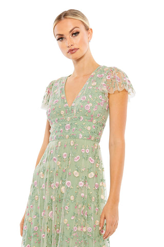 Waist-up view of the sage floral embroidered cap sleeve midi dress showing the V-neckline, cap sleeves and floral embroidery by Mac Duggal at Mrs. G