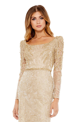 Waist-up view of the light gold leaf applique long sleeve mermaid gown showing the scoop neckline and beaded leaf appliques on the shoulders by Mac Duggal at Mrs. G