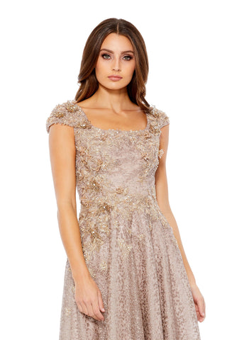 Waist-up view of the mocha floral applique cap sleeve square neck A-line gown showing the square neckline and embellished cap sleeves by Mac Duggal at Mrs. G