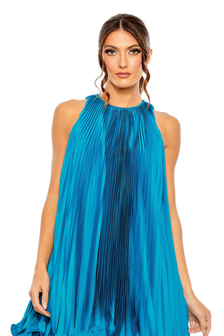 Waist-up view of the ocean blue pleated halter mini trapeze dress showing the gathered halter neckline and fine pleating by Mac Duggal at Mrs. G