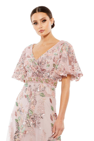 Waist-up view of the rose pink floral embellished short flutter sleeve gown showing the faux wrap bodice and beaded waist band by Mac Duggal at Mrs. G