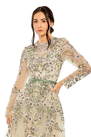 Waist-up view of the sage multi floral embroidered long sleeve gown showing the beaded high neckline and satin belt by Mac Duggal at Mrs. G