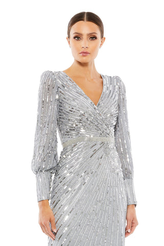 Waist-up view of the silver sequin wrap bishop sleeve gown showing the V neckline and crystal waist band by Mac Duggal at Mrs. G