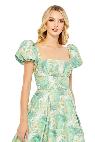Waist-up view of the spring green floral puff sleeve high low brocade dress showing the square neckline and puff sleeves by Mac Duggal at Mrs. G