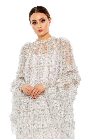 Waist-up view of the white multi floral ruffle cape sleeve mesh short dress showing the ruffle-trimmed neckline and cape sleeves by Mac Duggal at Mrs. G