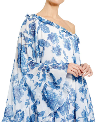Zoomed-in close-up of the ruffle trimmed one-shoulder neckline and blue rose print on white chiffon by Mac Duggal at Mrs. G