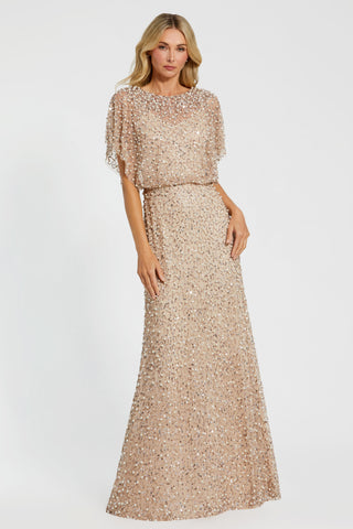 Full-length front view of the champagne gold beaded blouson gown with shawl sleeves by Mac Duggal at Mrs. G