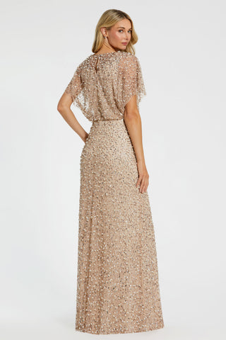 Three-quarter back view of the champagne gold beaded gown showing the shawl overlay and long skirt by Mac Duggal at Mrs. G