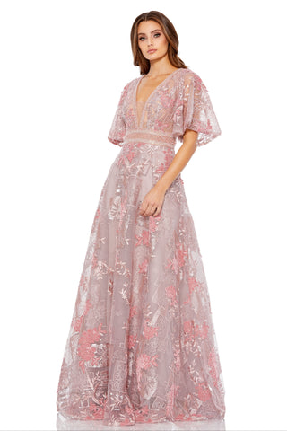 Full-length three-quarter view of the pink embroidered gown with deep V-neck and flounce sleeves by Mac Duggal at Mrs. G