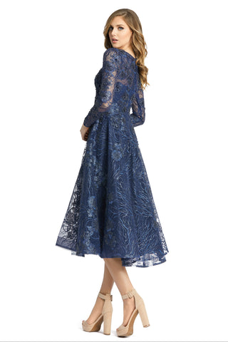 Three-quarter back view of the blue midi dress showing the sheer sleeves and full A-line skirt by Mac Duggal at Mrs. G