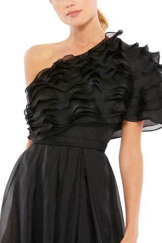 Zoomed-in close-up of the tiered sheer ruffles and banded waist on the black one-shoulder gown by Mac Duggal at Mrs. G