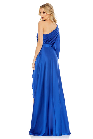 Back three-quarter view of the blue gown with the pleated one-shoulder bodice and long skirt by Mac Duggal at Mrs. G