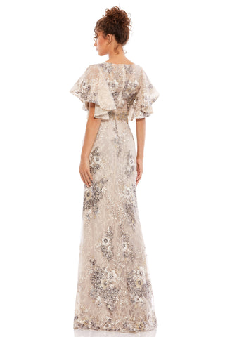 Back view of the beige embellished gown showing flared sleeves and embroidery down the skirt by Mac Duggal at Mrs. G