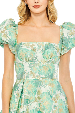 Close-up of the square neckline, puff sleeves and gold thread palm brocade on the spring green dress by Mac Duggal at Mrs. G