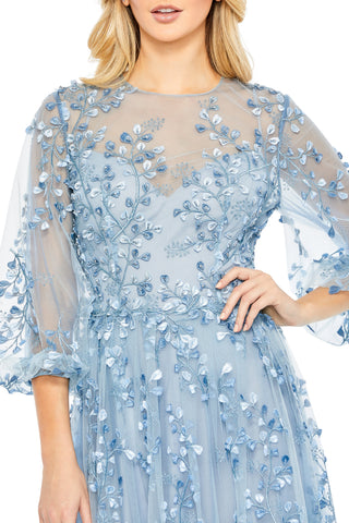 Close-up of the leaf-and-vine embroidery on the bodice and semi-sheer puff sleeve in blue by Mac Duggal at Mrs. G
