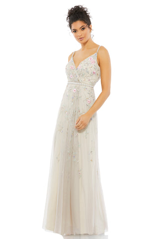 Three-quarter front view of the beige embroidered gown with V-neck, pearl straps and pearl waist by Mac Duggal at Mrs. G