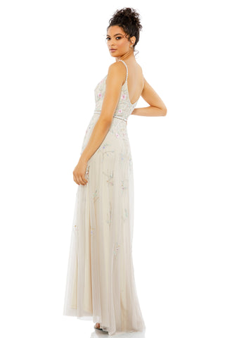 Three-quarter back view of the beige gown showing the scoop back and sheer A-line skirt by Mac Duggal at Mrs. G