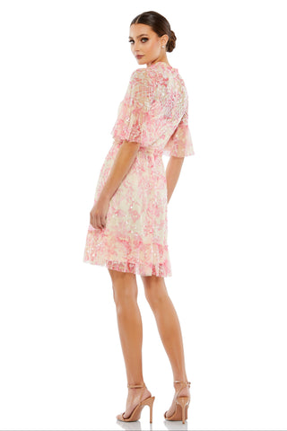 Back view of the pink floral sequin dress showing the sheer flounce sleeves and ruffled hem by Mac Duggal at Mrs. G