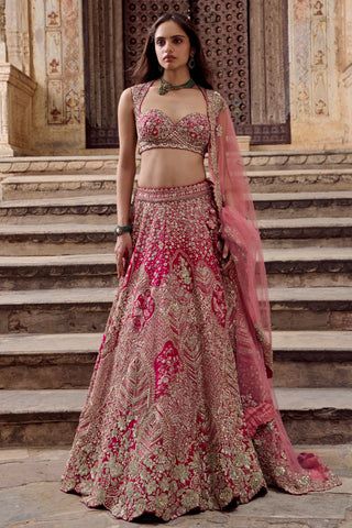 Front view of dark fuchsia bridal lehenga with sweetheart blouse and net dupatta on stone steps by Osaa by Adarsh at Mrs. G