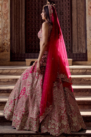 Side view of dark fuchsia bridal lehenga with veil showing the scalloped floral hem by Osaa by Adarsh at Mrs. G