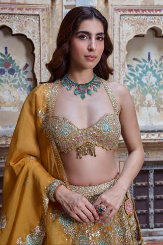 Close-up of honey orange halter blouse with scalloped edge and beaded tassel drop by Osaa by Adarsh at Mrs. G