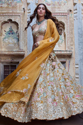 Low-angle view of honey orange full skirt and sequin-edged organza dupatta by Osaa by Adarsh at Mrs. G