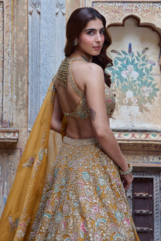 Over-the-shoulder view of honey orange open back blouse and zardozi skirt by Osaa by Adarsh at Mrs. G