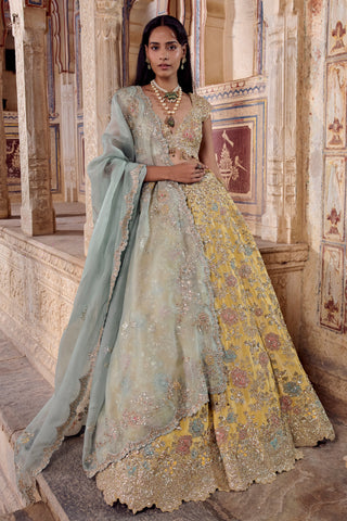 Front three-quarter view of the maize yellow lehenga with scalloped hem and draped organza dupatta by Osaa by Adarsh at Mrs. G
