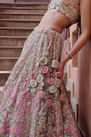 Close-up of raised coral and fuchsia roses and floral tassels on the oyster pink lehenga skirt by Osaa by Adarsh at Mrs. G