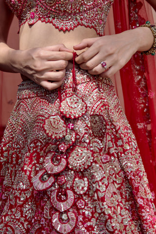 Close-up of tassel latkan of embroidered medallions on the rosewood red lehenga waistband by Osaa by Adarsh at Mrs. G