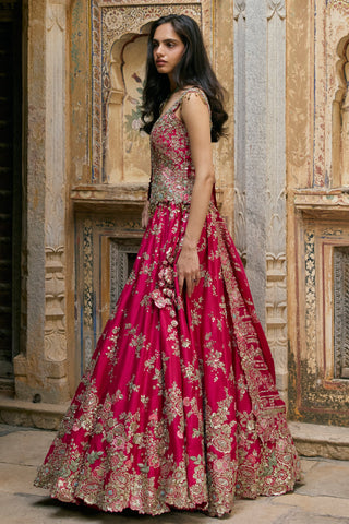 Side view of ruby pink flared lehenga with appliquéd rose border and dupatta by Osaa by Adarsh at Mrs. G