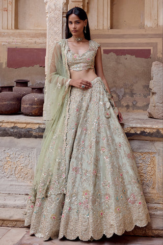 Standing view of sage lehenga set in an arched doorway with floral skirt and scalloped border by Osaa by Adarsh at Mrs. G